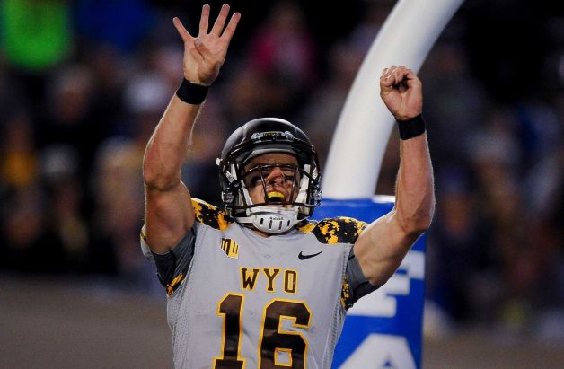 Wyoming quarterback Brett Smith raises the 4-0 after a touchdown scramble vs. Air Force on Saturday night. (Photo courtesy of Michael Ciaglo of The Gazette)