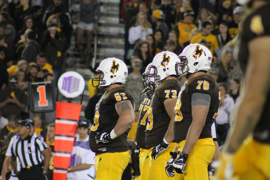 The Wyoming offensive line gets ready pre-snap before in a recent game vs Air Force. (Photo via KFBC Radio)