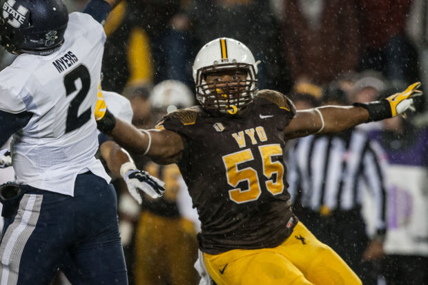 Wyoming defensive end Eddie Yarbrough interrupts the backfield while Utah State's Kent Myers attempts a pass. Yarbrough is a pre-season 1st team All-MW selection. (Photo via Ryan Dorgan/Casper Star Tribune)