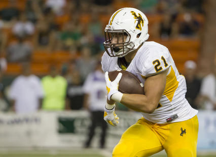 Shaun Wick carries the football in a game against Hawai'i (AP Photo/Eugene Tanner)