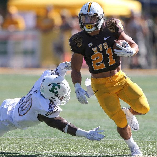 University of Wyoming Shaun Wick runs by Great Ibe of Eastern Michigan University at Jonah Field at War Memorial Stadium. Wick will return to the Pokes this season after receiving a medical redshirt. (Photo via Michael Smith/UW)